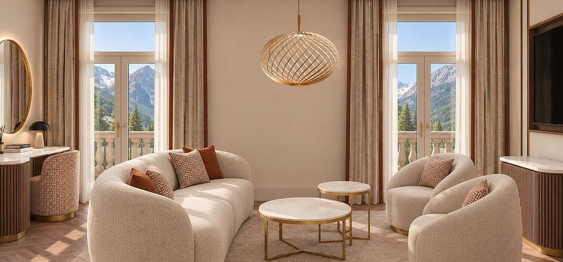 Großzügiger Wohnbereich der Superior Suite im Art-Déco-Stil mit zwei Sofa, zwei Balkonzugängen und Blick auf das Karwendelgebirge.