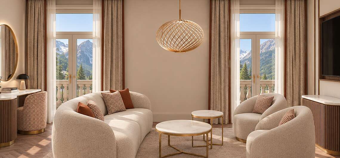 Großzügiger Wohnbereich der Superior Suite im Art-Déco-Stil mit zwei Sofa, zwei Balkonzugängen und Blick auf das Karwendelgebirge.
