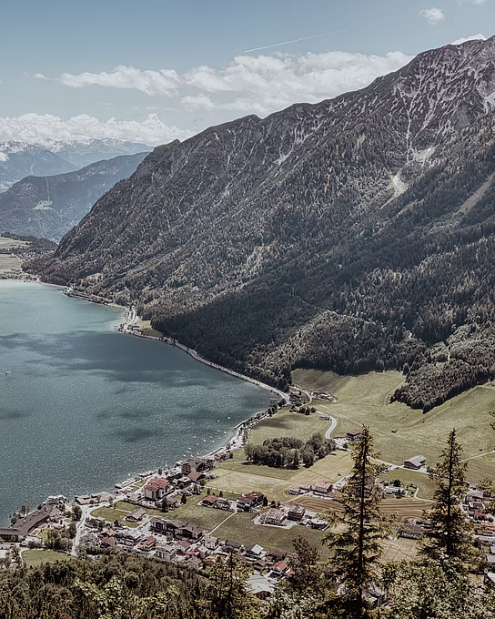 Vogelperspektive auf den türkisblauen Achensee, umgeben von den Tiroler Alpen