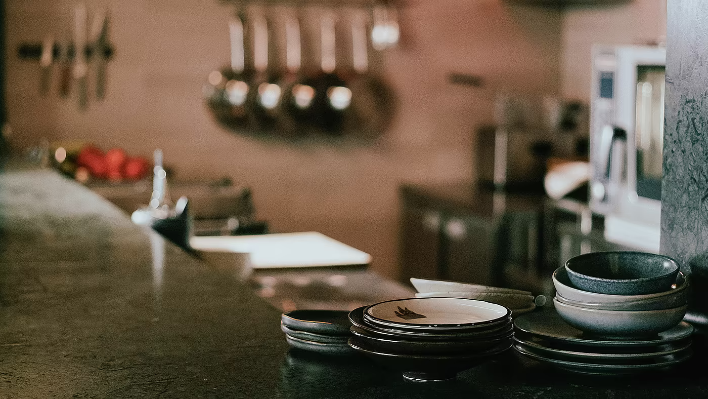 Vorbereiteter Küchenarbeitsplatz mit Geschirr und Utensilien in der Hotelküche.