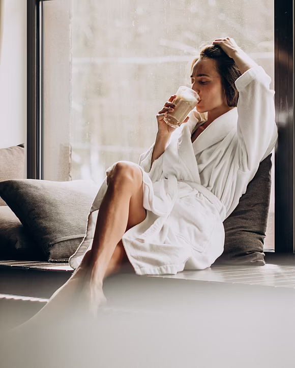 Junge Frau im Wellnessbereich geniesst Getränk