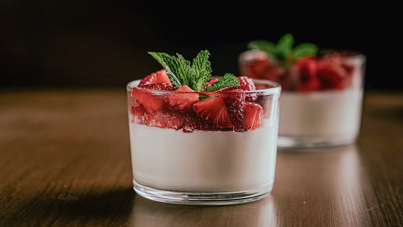 Dessert im Glas mit frischen Erdbeeren und Creme, angerichtet in der Hotelküche.