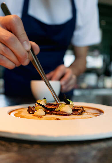 Gourmetrestaurant am Achensee – Koch beim Anrichten eines Fine-Dining-Gerichts im Siegfrieds beim See im Mazaggs – Alpenhof