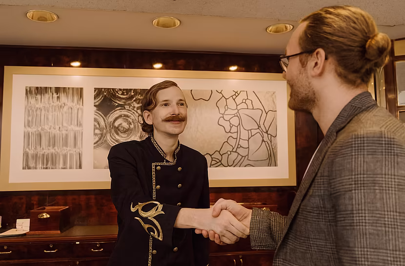 Rezeptionsmitarbeiter begrüsst Gast im Mazaggs