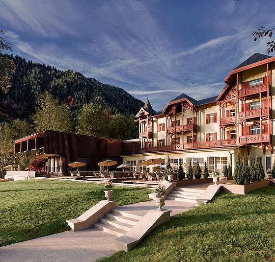 Außenansicht des Designhotels am Achensee mit Garten und Tiroler Bergkulisse